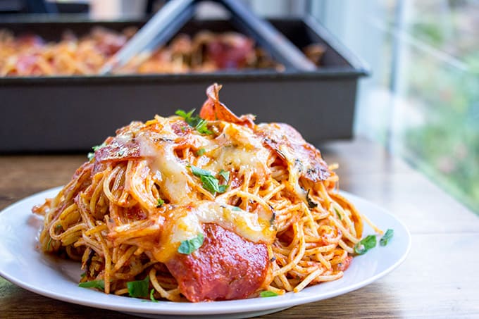 A mix of pepperoni pizza and cheesy marinara pasta, this Easy Baked Pepperoni Pizza Spaghetti is a fun alternative to pizza night and perfect for a crowd! dinnerthendessert.com