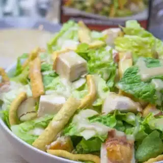 salad with chicken and toppings in a white bowl