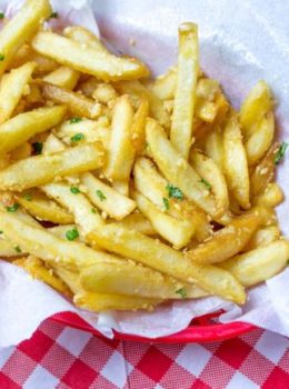 Oven Baked Loaded Garlic French Fries tossed in slightly warmed chopped garlic, olive oil and kosher salt, just like you enjoy at the ball game!