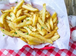 Oven Baked Loaded Garlic French Fries tossed in slightly warmed chopped garlic, olive oil and kosher salt, just like you enjoy at the ball game!