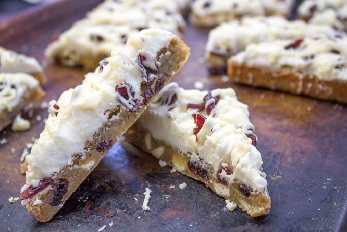 Starbucks White Chocolate Cranberry Bliss Bars are a delicious blondie cookie bar with white chocolate topped with sweet cream cheese icing, tart dried cranberries, and a sweet white chocolate orange drizzle.