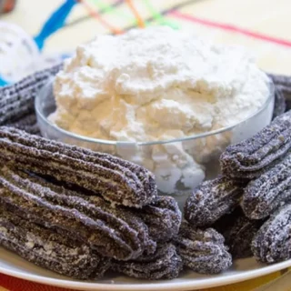 plated churros with whipped cream