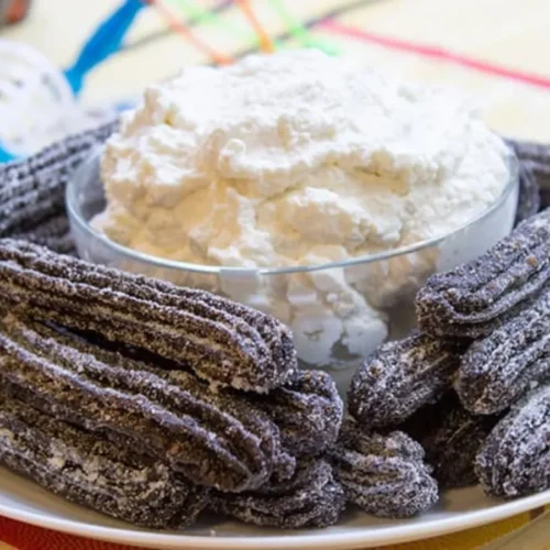 plated churros with whipped cream