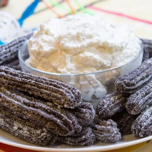 plated churros with whipped cream