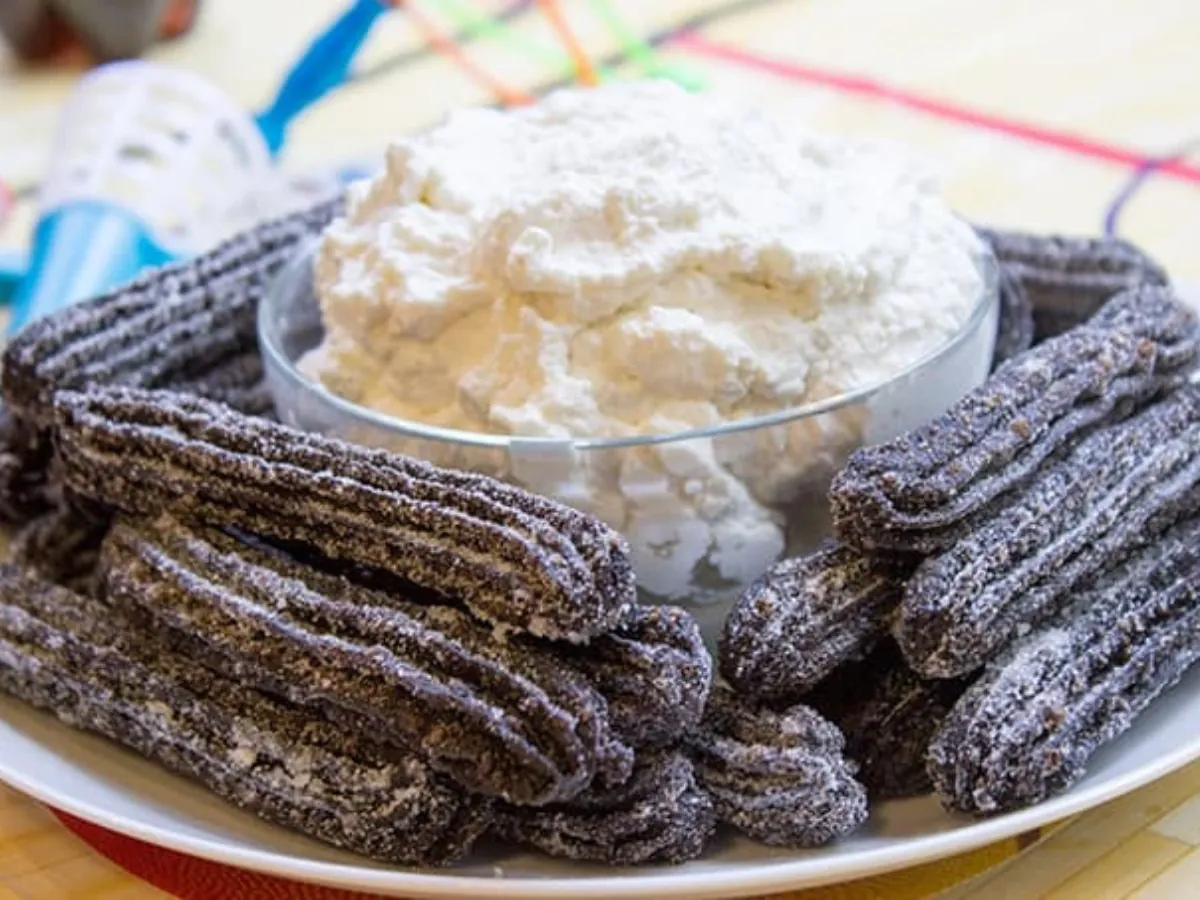 plated churros with whipped cream