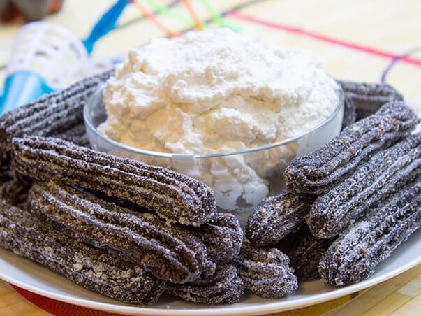 pile of churros made of oreo on plate with dipping
