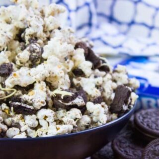 Sweet cookies and cream popcorn with Oreos on the side and dish towel in the background