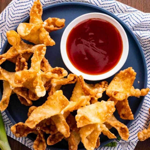 Plate of fried rangoons with bowl of sweet sour sauce