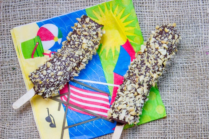 Disney Chocolate Covered Frozen Bananas are a popular treat inside the parks, at amusement parks and beaches across the world. Frozen Bananas dipped in melted homemade chocolate magic shell and covered in peanuts. The perfect slightly healthy treat!