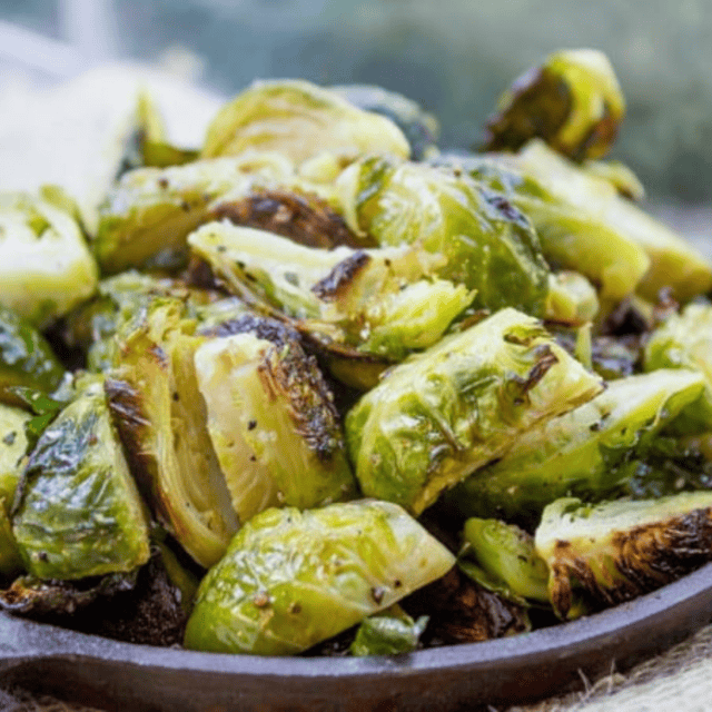Crispy seasoned Brussels sprouts in a skillet.