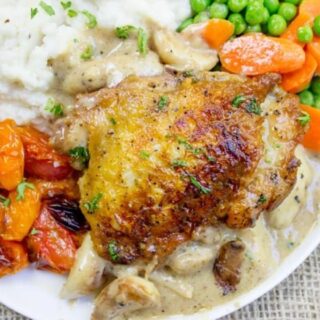 Chicken on a dinner plate with vegetables.
