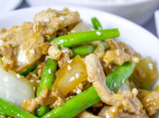 Panda Express String Bean Chicken Breast with onions cooked quickly in a wok in a light ginger soy sauce.