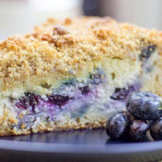 Blueberry Coffee Cake slice on a plate with blueberries
