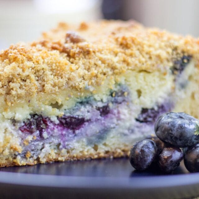 Blueberry Coffee Cake slice on a plate with blueberries