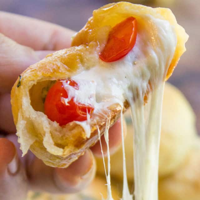 Caprese Pizza Bombs are a quick, fun treat or appetizer with fresh mozzarella, basil and cherry tomatoes. Plus the stretchy cheese factor is amazing.