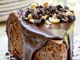 Rich Chocolate Hazelnut Cheesecake made with Chocmeister Milk Chocolatey Hazelnut Spread, a chocolate cookie crust and a thick, glossy chocolate ganache.