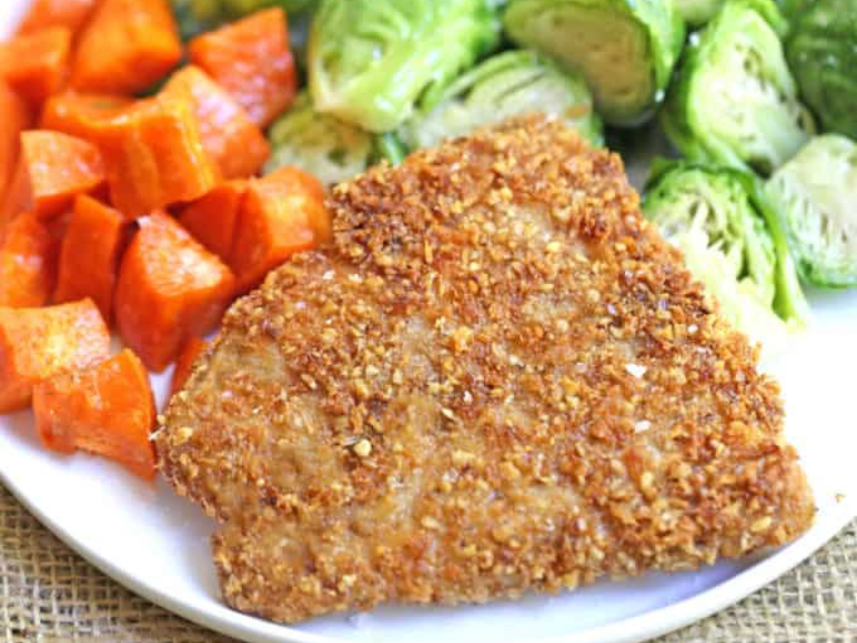 fish on a white plate with brussels sprouts and sweet potato