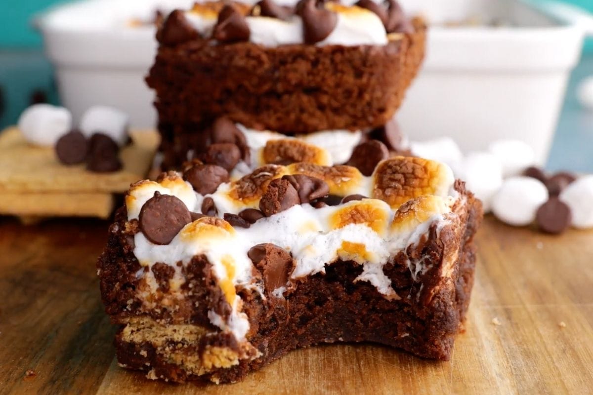 S'mores Brownies stacked on cutting board with bite taken