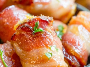 Bacon Wrapped Tater Tot Bombs are an easy appetizer of tater tots and sharp cheddar cheese wrapped in thick cut bacon, rolled in brown sugar and baked.