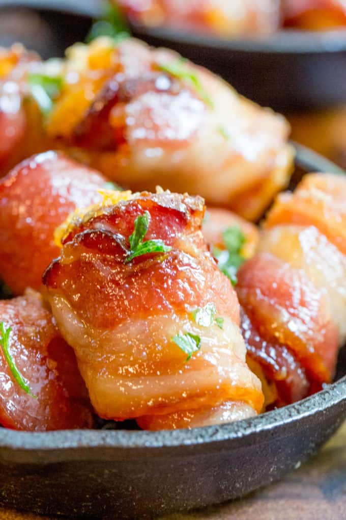 Bacon Wrapped Tater Tot Bombs are an easy appetizer of tater tots and sharp cheddar cheese wrapped in thick cut bacon, rolled in brown sugar and baked.