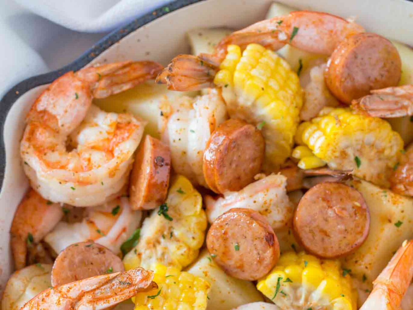 seafood, meat, and veggies in a pot with cajun seasonings