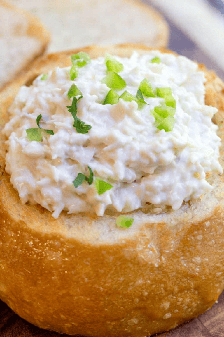 creamy dip in a bread bowl with green onion topping