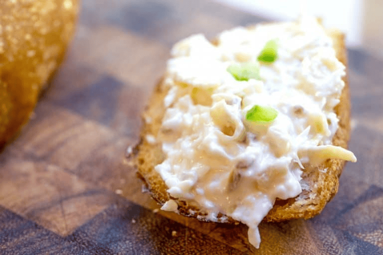 Creamy dip spread over bread slice