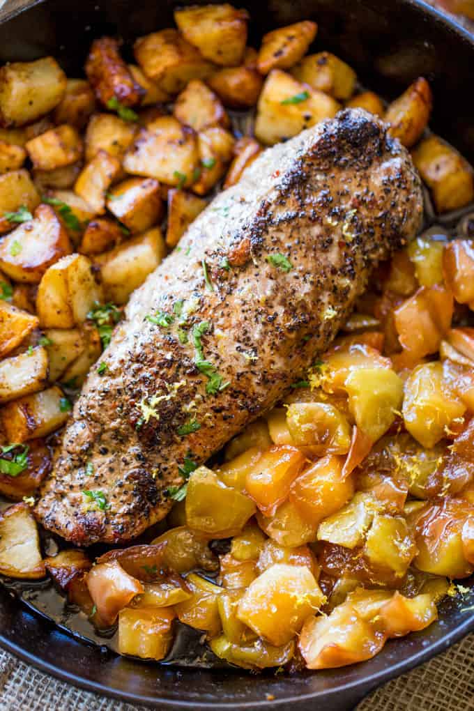 cooked pork loin surrounded by potatoes and apples