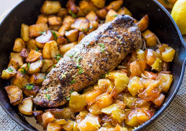 pork loin on bed of potatoes in black skillet