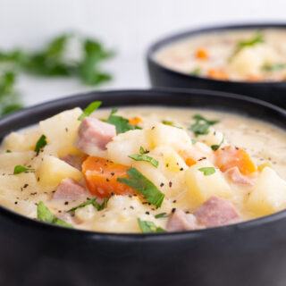 Slow Cooker Ham and Potato Soup in bowls with parsley garnish