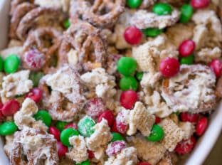 Christmas White Chocolate Trash Snack Mix with pretzels, cereal, peanuts and chocolate coated candies all tossed together with a generous coating of white chocolate.