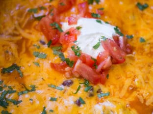 Slow Cooker Chicken Enchilada Dip takes just five minutes of prep with raw chicken, enchilada sauce and veggies topped with a bunch of deliciously melty cheddar cheese.