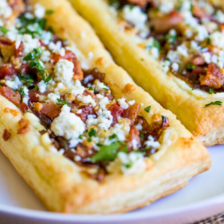 crispy pork, dairy spread, and greens on a baked pastries