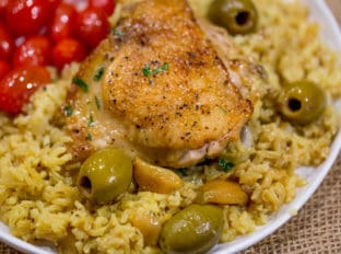Spanish Olives Chicken and Rice made in a single cast iron skillet is a gorgeous meal made easy with delicious Spanish queen green olives, caramelized onions, garlic and saffron rice.