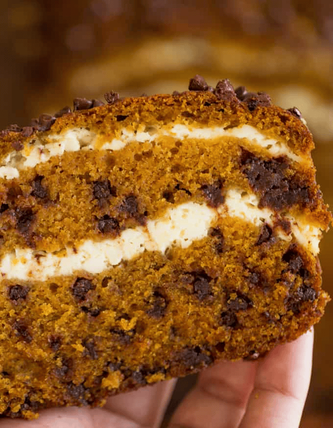 Slice of pumpkin bread with mini chocolate chips and cream cheese filling visible