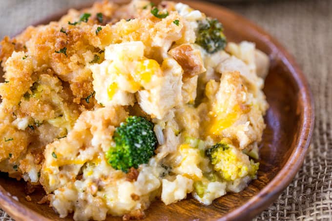 cheesy chicken and rice with broccoli dish served on wooden plate