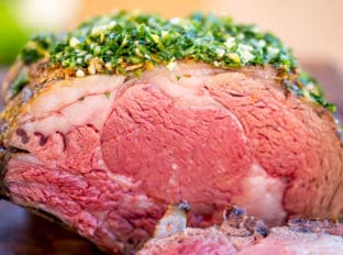 Perfect Garlic Prime Rib made with a garlic, thyme and rosemary crust is gorgeously browned on the outside and a perfect medium on the inside. Topped of with a gremolata it is the perfect show-stopping holiday/event meal!
