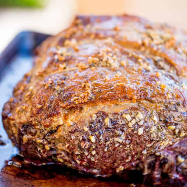 Perfect Garlic Prime Rib made with a garlic, thyme and rosemary crust is gorgeously browned on the outside and a perfect medium on the inside. Topped of with a gremolata it is the perfect show-stopping holiday/event meal!