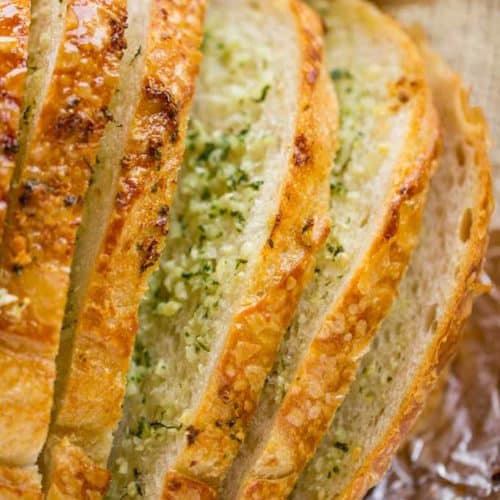 Sliced Garlic Bread Loaf made with a pre-sliced loaf of bread in just minutes and enough to feed a large crowd with no mess or slicing involved. In the oven in minutes.