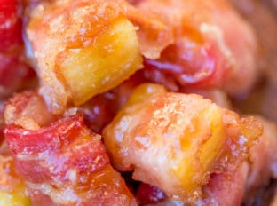 Spicy Sweet Bacon Wrapped Pineapple Bites caramelized with brown sugar and hot sauce make a perfect sticky, sweet, spicy, fruity bacon bite your guest will love in just minutes!