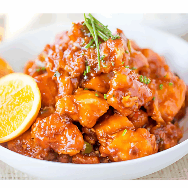 chicken in bowl with slice of lemon and greens