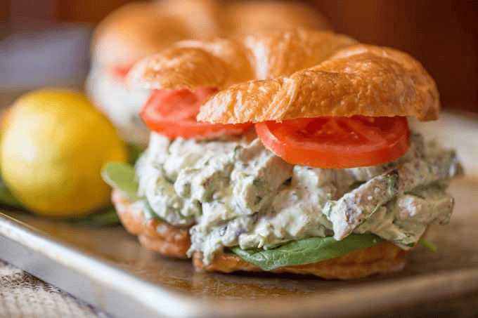 Chicken salad with lemon in the background