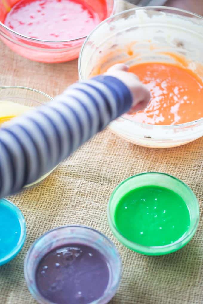child pointing at bowls of colors 