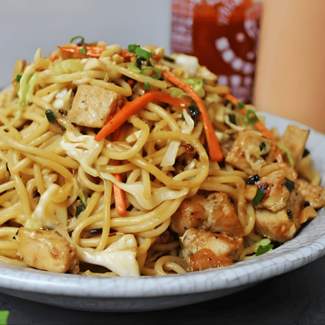 cooked poultry, and veggies with noodles on a plate