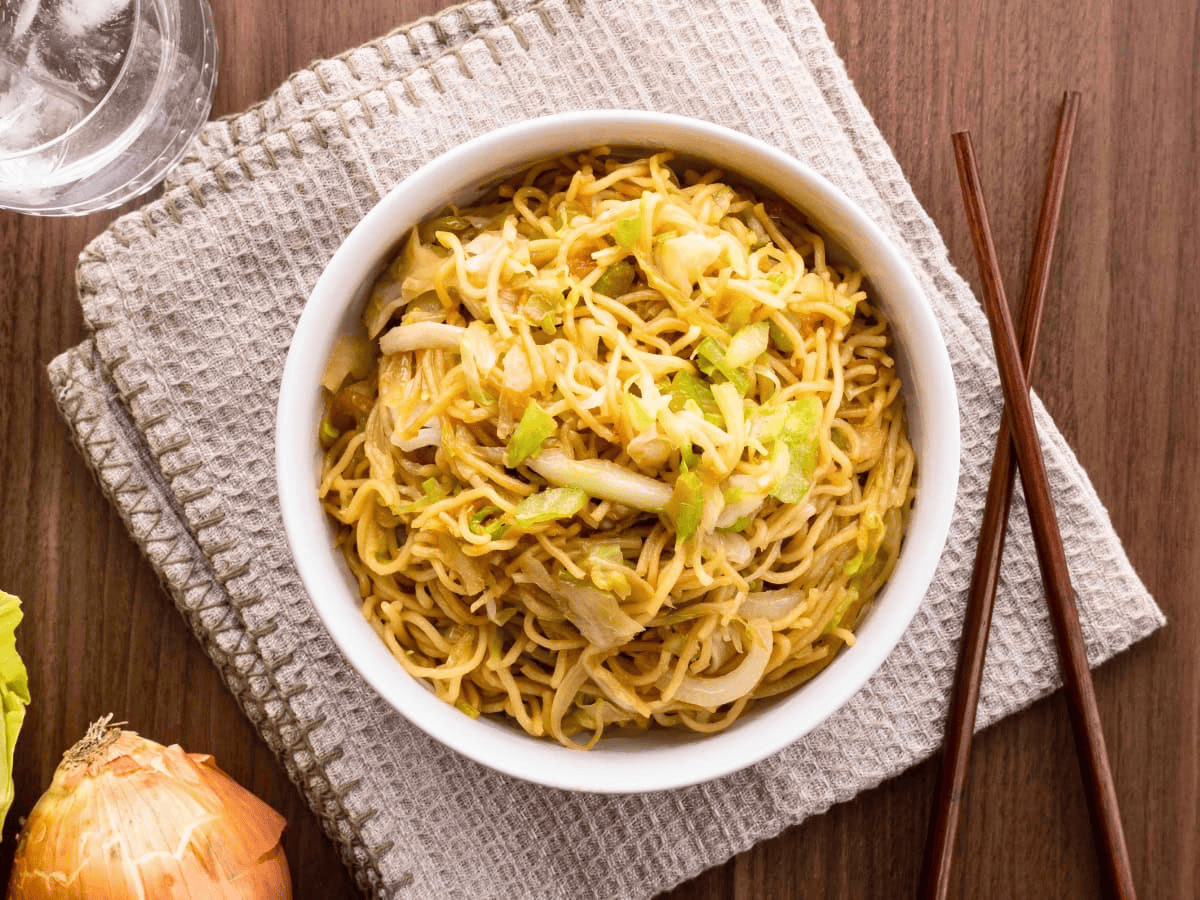 Noodles in white bowl with chop sticks