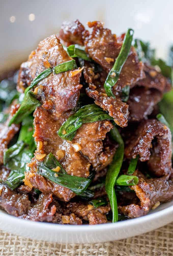 Mongolian Beef cooked steak and onions in pile on plate