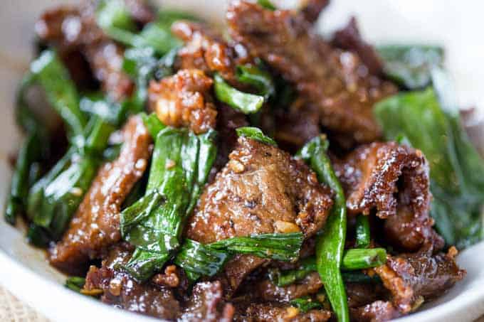 Mongolian Beef cooked steak and onions in pile on plate