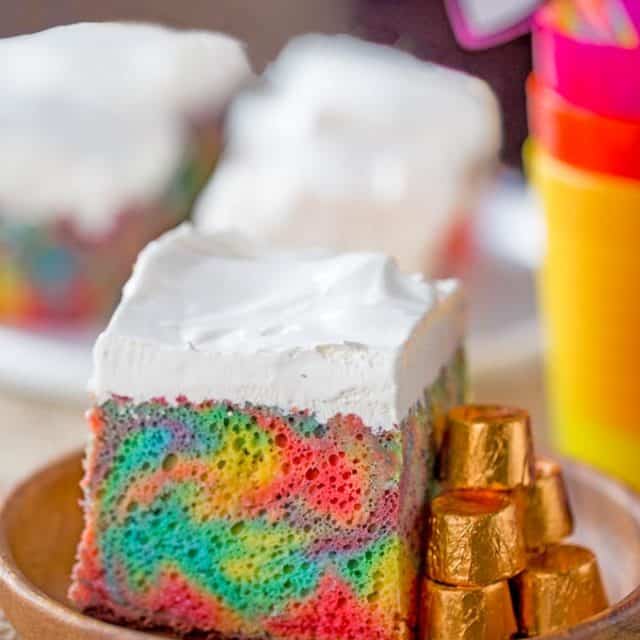 Rainbow Poke Cake With Whipped Cream made with no cake mix. Condensed milk makes this poke cake super moist and fluffy stabilized whipped cream won't melt!