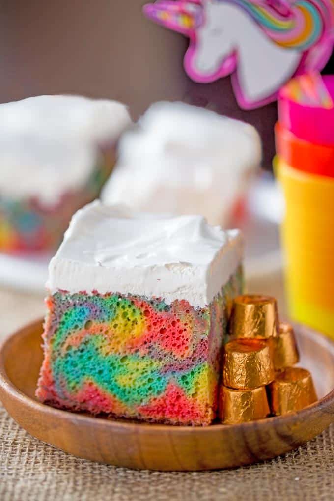 Rainbow Poke Cake With Whipped Cream made with no cake mix. Condensed milk makes this poke cake super moist and fluffy stabilized whipped cream won't melt!