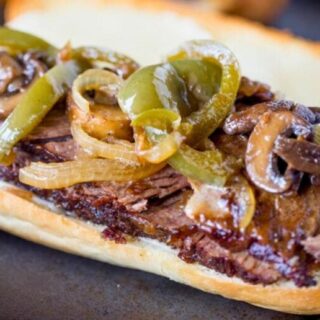 Steak sandwich with roasted peppers on top